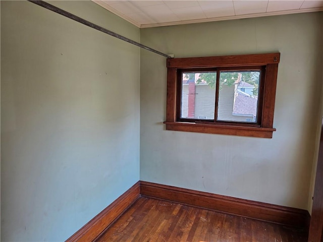 unfurnished room with crown molding and dark hardwood / wood-style flooring