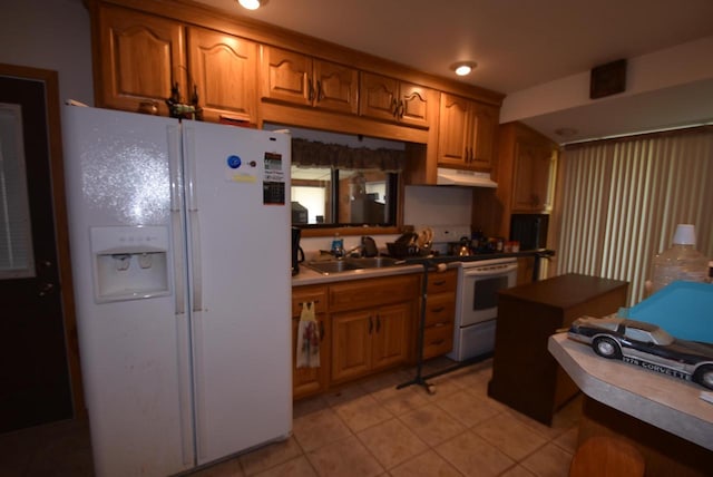 kitchen featuring sink, light tile patterned floors, and white appliances