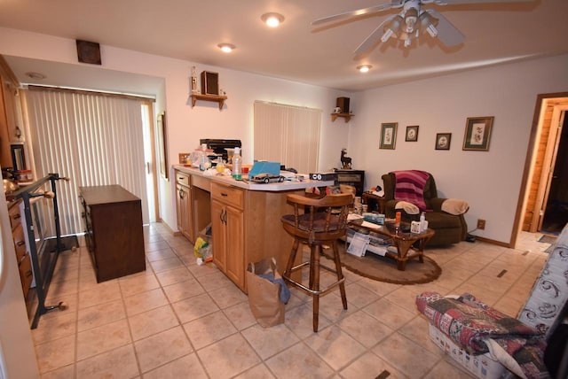 kitchen with a center island, ceiling fan, a breakfast bar area, and light tile patterned flooring