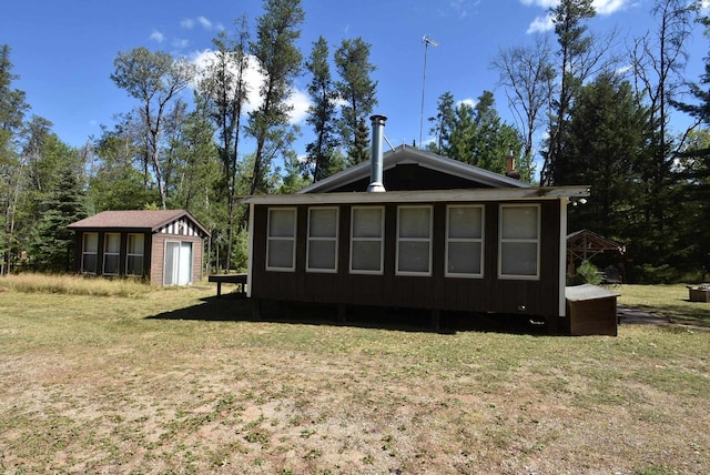 rear view of house featuring an outbuilding, a yard, and a garage