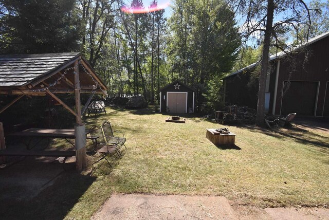 view of yard featuring a fire pit and a storage unit