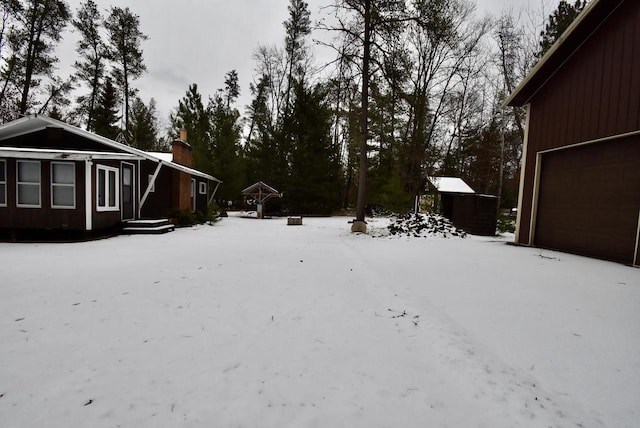 snowy yard with a garage