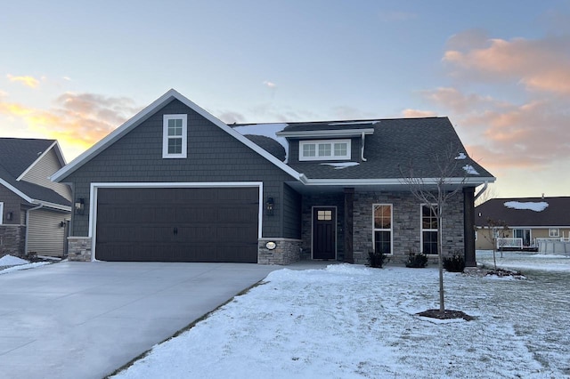 view of front of house featuring a garage, stone siding, and driveway