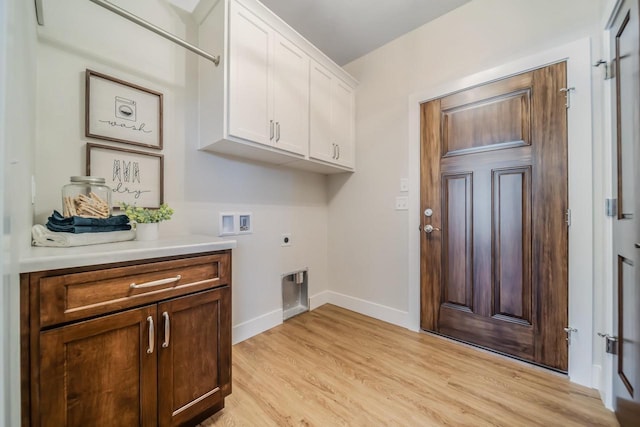 clothes washing area with washer hookup, light wood-style flooring, cabinet space, baseboards, and hookup for an electric dryer