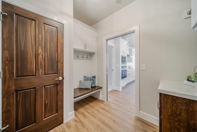 mudroom featuring light wood-style flooring and baseboards