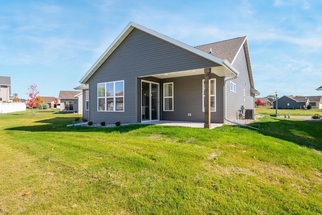 back of house featuring cooling unit, a patio, and a lawn