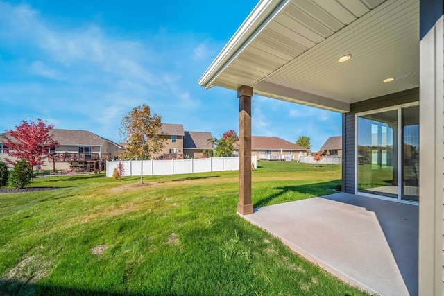 view of yard with a patio, fence, and a residential view