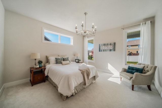 bedroom featuring multiple windows, light carpet, baseboards, and a chandelier