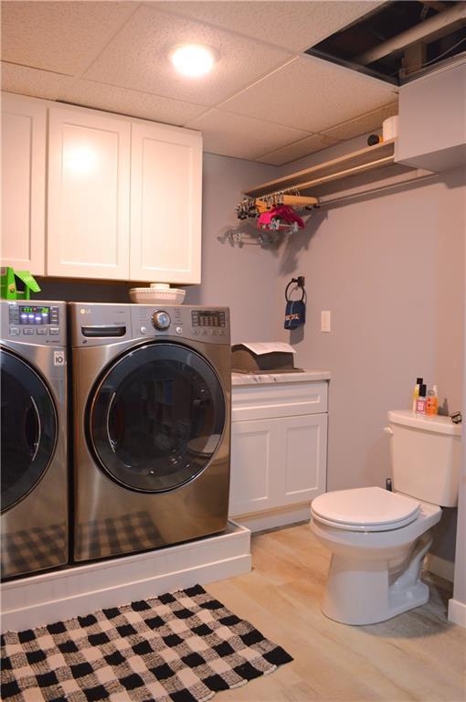 laundry room with wood-type flooring and washer and dryer