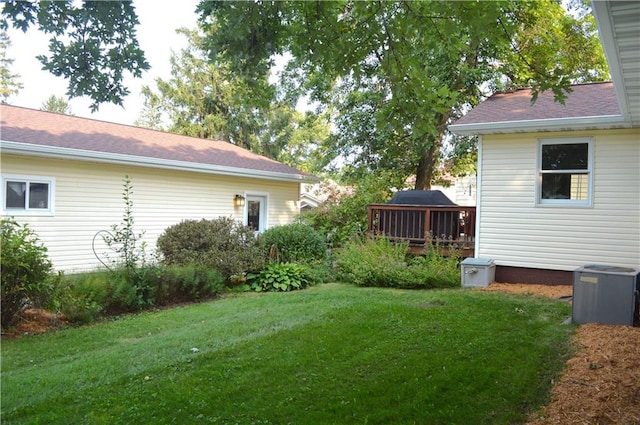 view of yard with central air condition unit and a deck