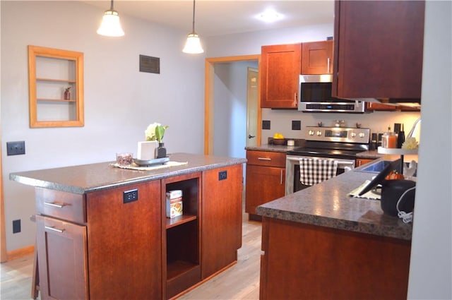 kitchen with pendant lighting, light hardwood / wood-style flooring, a kitchen island, and stainless steel appliances