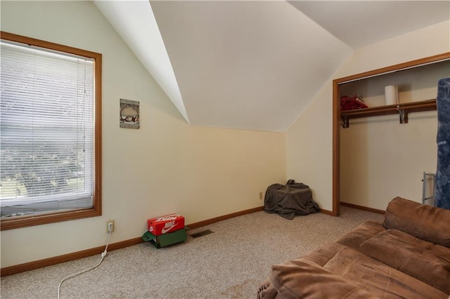 interior space featuring vaulted ceiling and light carpet