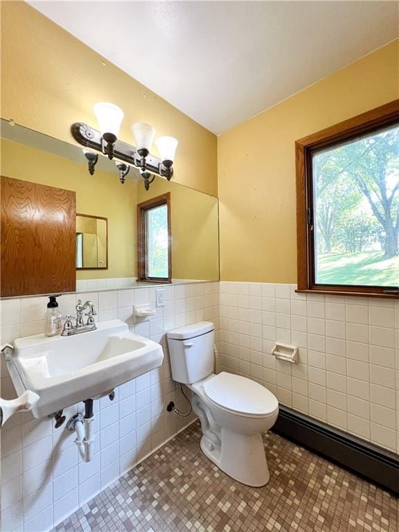 bathroom featuring toilet, tile patterned flooring, decorative backsplash, a baseboard heating unit, and tile walls