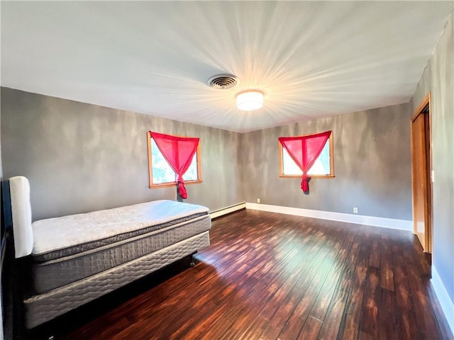 unfurnished bedroom featuring dark hardwood / wood-style flooring and a baseboard radiator