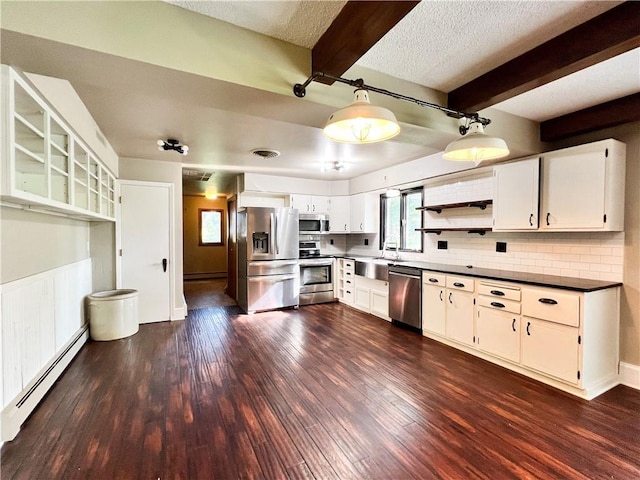 kitchen featuring dark hardwood / wood-style floors, a baseboard radiator, stainless steel appliances, sink, and white cabinetry