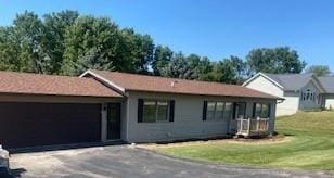 ranch-style home featuring a front lawn and a garage