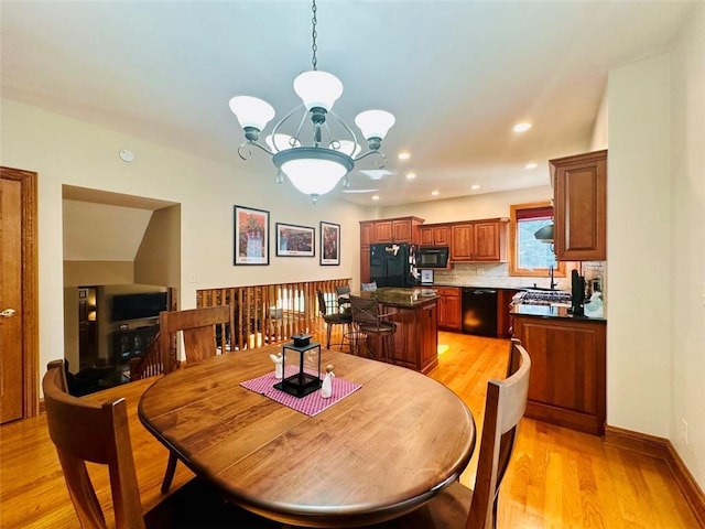 dining space featuring an inviting chandelier, recessed lighting, light wood-type flooring, and baseboards