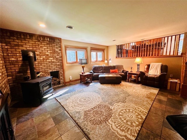 living area with visible vents, a wood stove, and baseboards