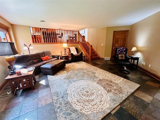 living area featuring stairway, visible vents, baseboards, and stone tile flooring