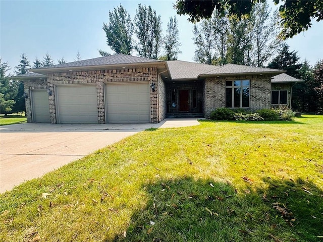 view of front of property featuring driveway, a front yard, brick siding, and an attached garage