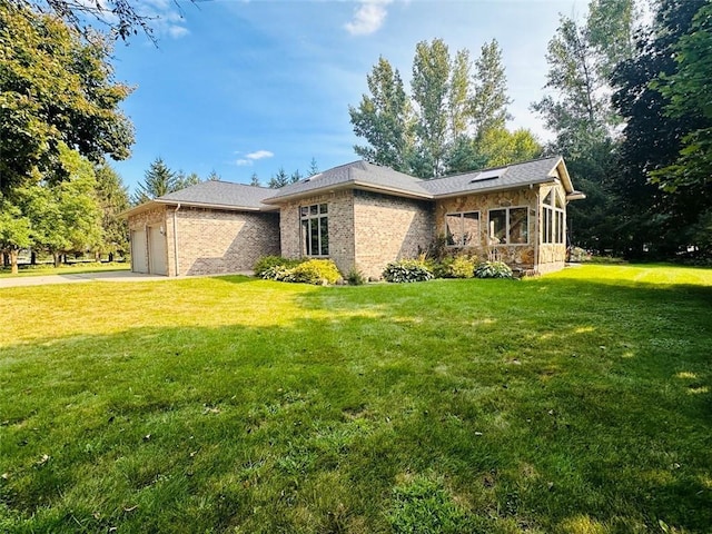 view of property exterior with an attached garage, a yard, and driveway