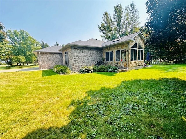 view of side of home with a yard and driveway