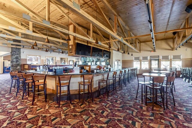 kitchen with dark colored carpet, beamed ceiling, high vaulted ceiling, and wooden ceiling