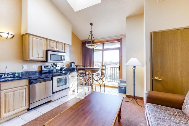 kitchen featuring pendant lighting, stainless steel appliances, light tile patterned floors, and light brown cabinetry