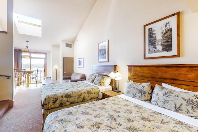 carpeted bedroom featuring vaulted ceiling with skylight and visible vents