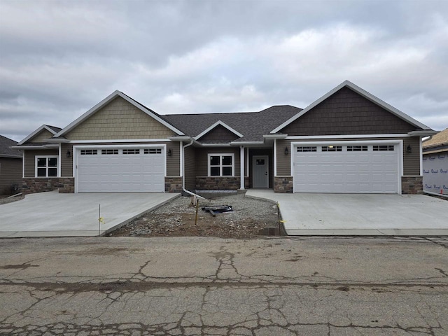 craftsman-style house featuring a garage, stone siding, and driveway