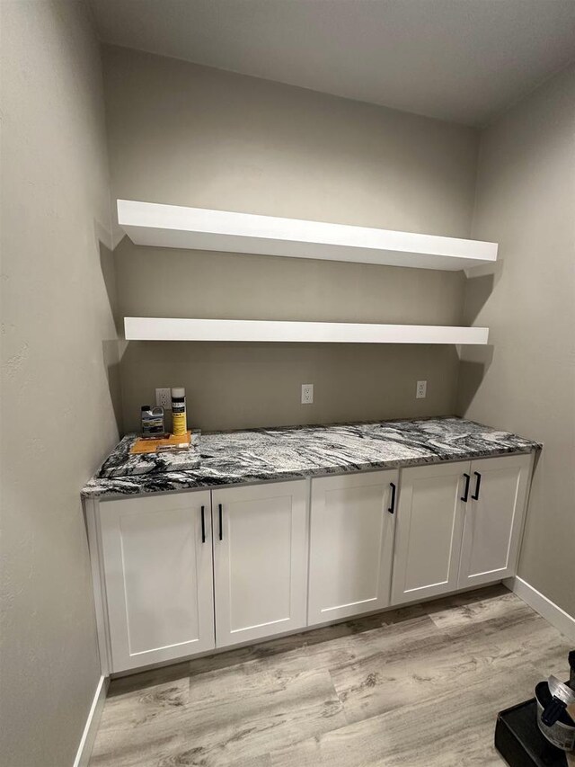 bar with light wood finished floors and baseboards