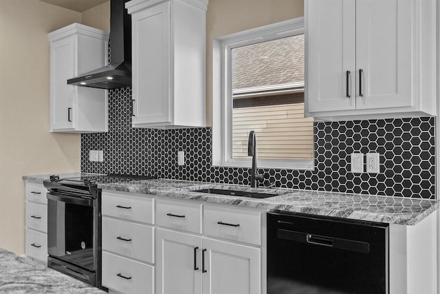 kitchen with wall chimney exhaust hood, backsplash, white cabinetry, a sink, and black appliances