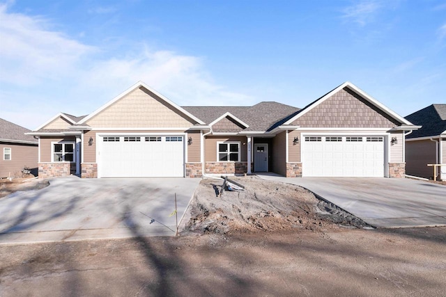 craftsman-style home featuring an attached garage, stone siding, and driveway