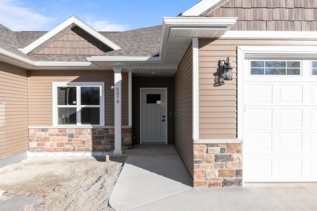 entrance to property with stone siding, a shingled roof, and an attached garage