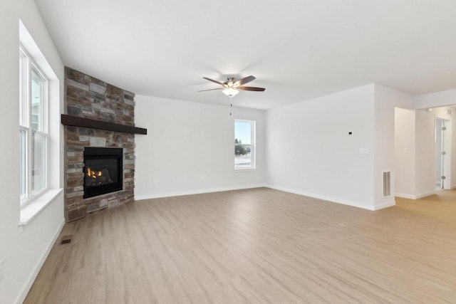 unfurnished living room with ceiling fan, light wood-type flooring, and a fireplace