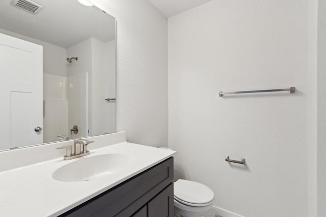 bathroom with vanity, toilet, and a shower