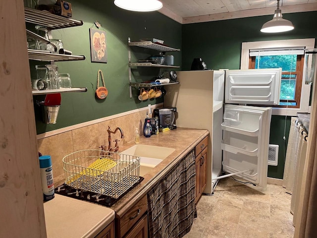 kitchen featuring ornamental molding, hanging light fixtures, and sink