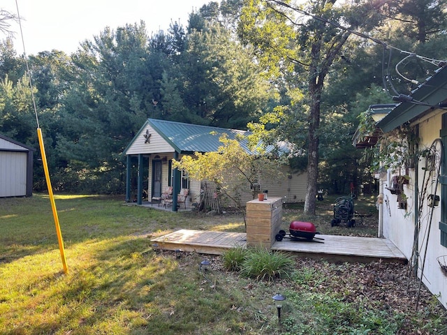 view of yard with a wooden deck and a storage unit