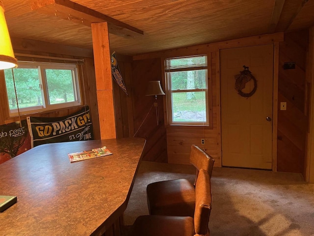 dining area with wood ceiling, wood walls, and carpet