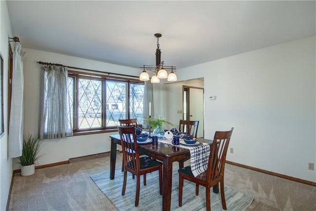 dining room featuring a baseboard radiator, an inviting chandelier, and light carpet