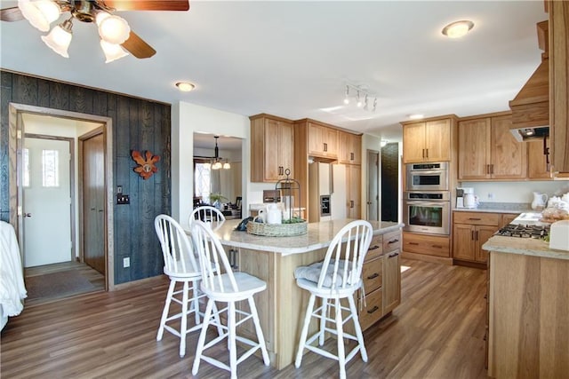 kitchen featuring stainless steel double oven, hardwood / wood-style flooring, ceiling fan, and a healthy amount of sunlight