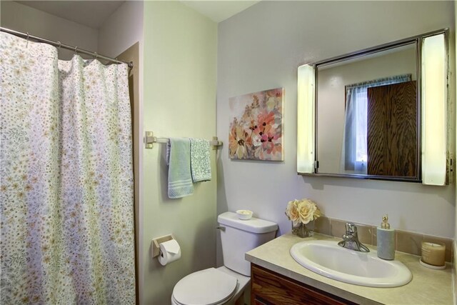 bedroom featuring multiple closets, light colored carpet, ensuite bath, and ceiling fan