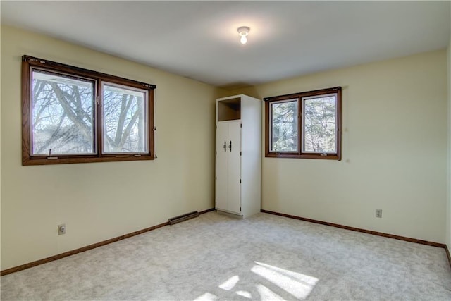 spare room featuring a wealth of natural light and light colored carpet