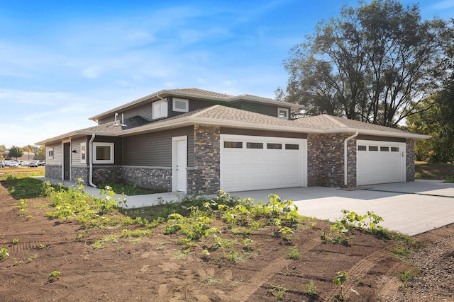 view of side of property featuring a garage, stone siding, and driveway