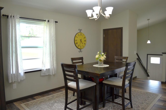 dining area with dark hardwood / wood-style floors and a chandelier