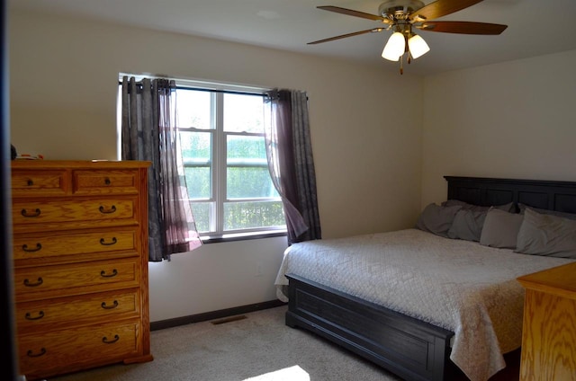 carpeted bedroom featuring ceiling fan and multiple windows