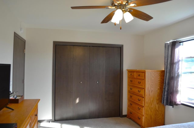 carpeted bedroom with multiple windows, ceiling fan, and a closet