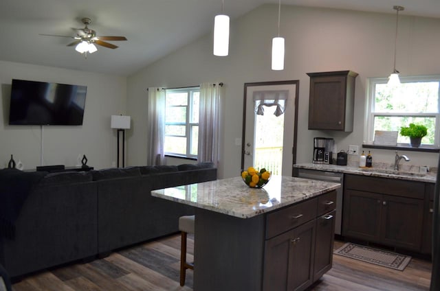 kitchen with light stone countertops, pendant lighting, dark hardwood / wood-style flooring, and ceiling fan