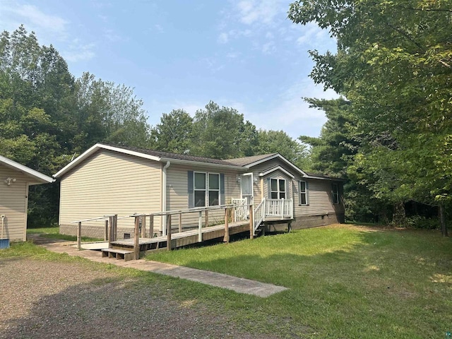 manufactured / mobile home featuring a deck and a front lawn