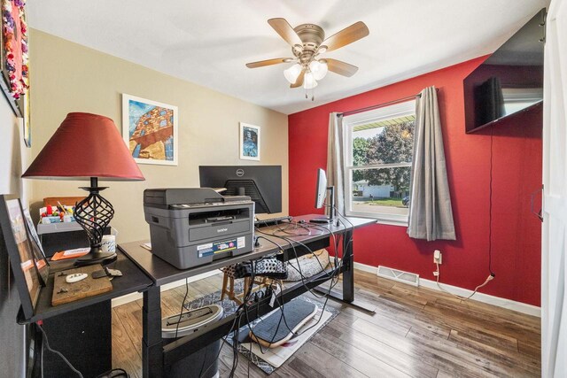 home office featuring visible vents, ceiling fan, baseboards, and wood finished floors